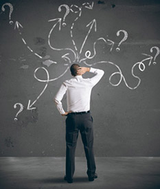 Businessman looking at arrows pointing in different directions